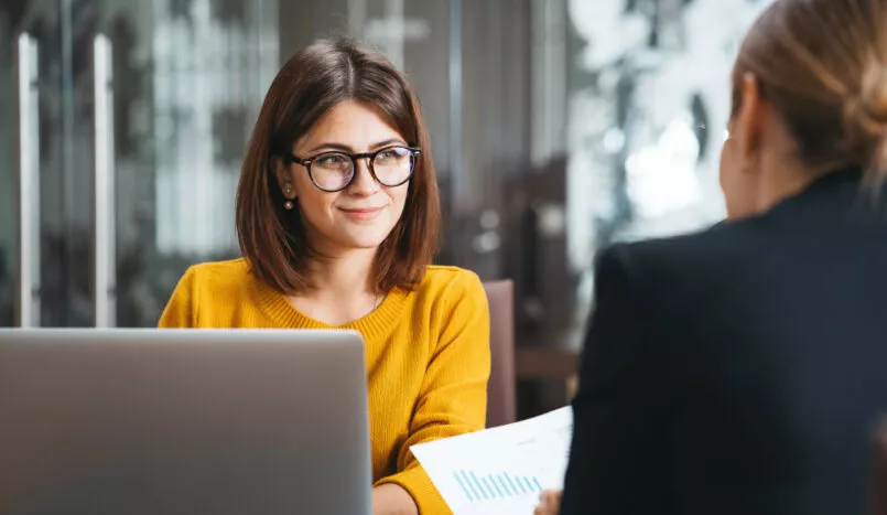 Une jeune femme semble écouter une collègue de travail lors d'une réunion