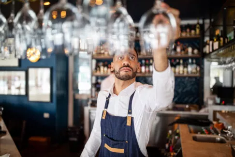 Un barman dans un café s'apprêtant à prendre un verre à pied