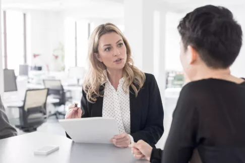 Deux jeune femmes collègues discutent entre elles sur leur lieu de travail