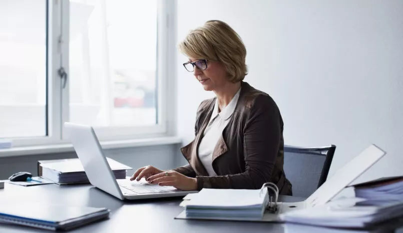 Femme semblant très sérieuse travaillant sur son ordinateur portable au bureau