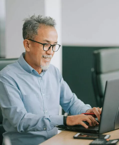 Un homme travaillant via son ordinateur portable au bureau