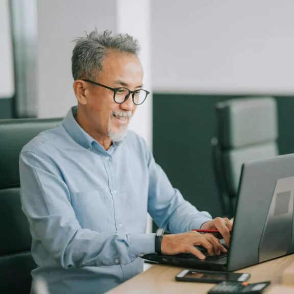 Un homme travaillant via son ordinateur portable au bureau