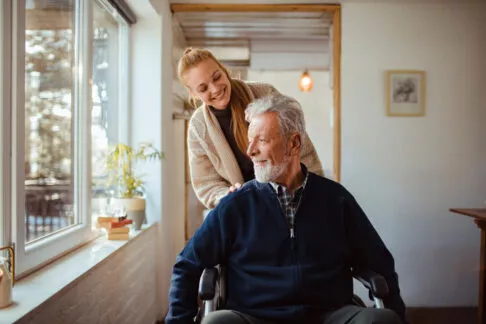 Une jeune femme aidant son père à se déplacer en fauteuil roulant